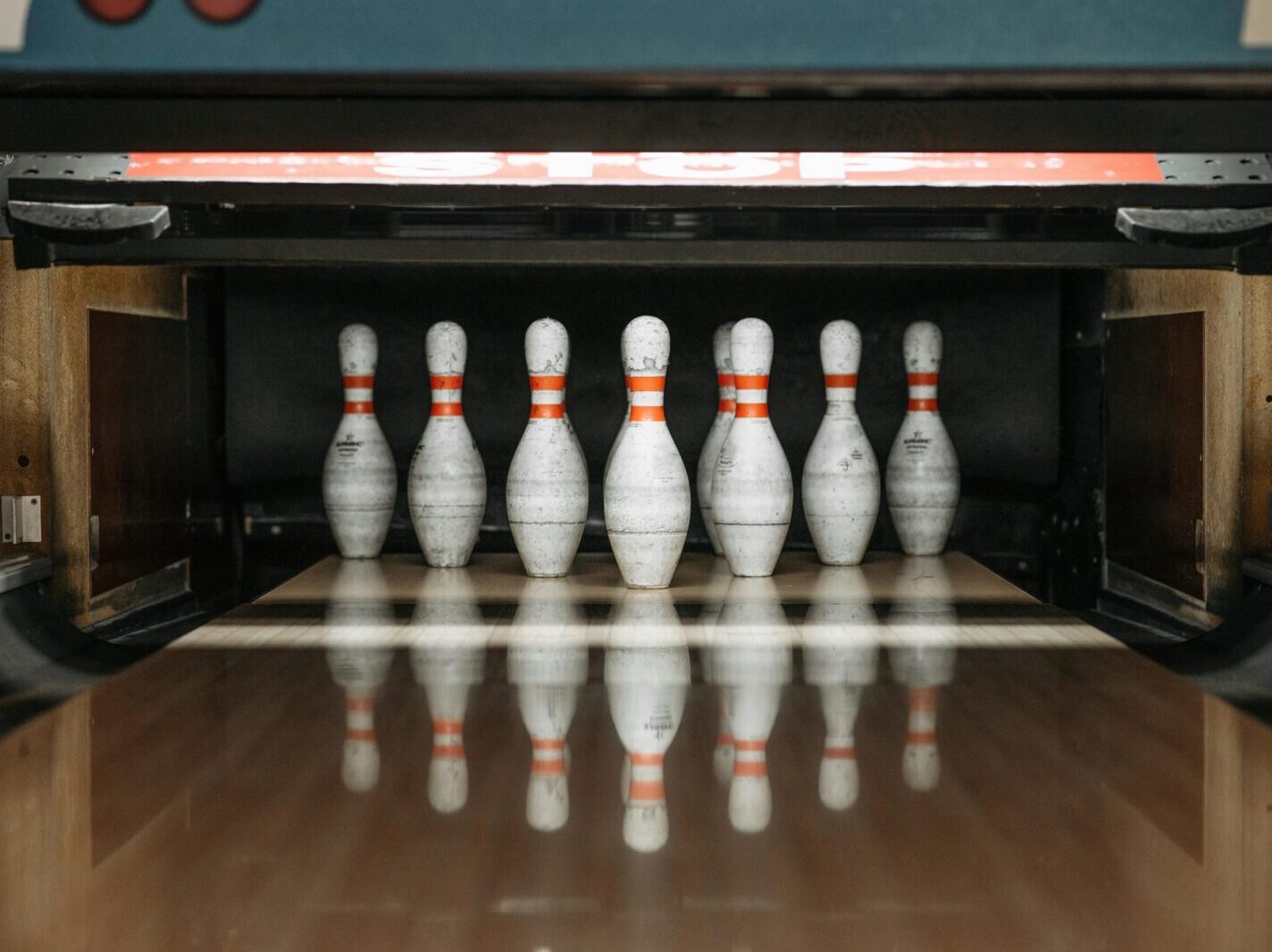 Seven bowling pins arranged in an alley, ready for a game.